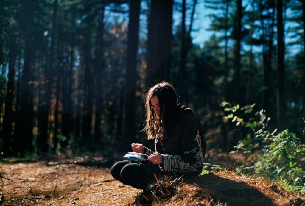 a person writing a journal in the woods